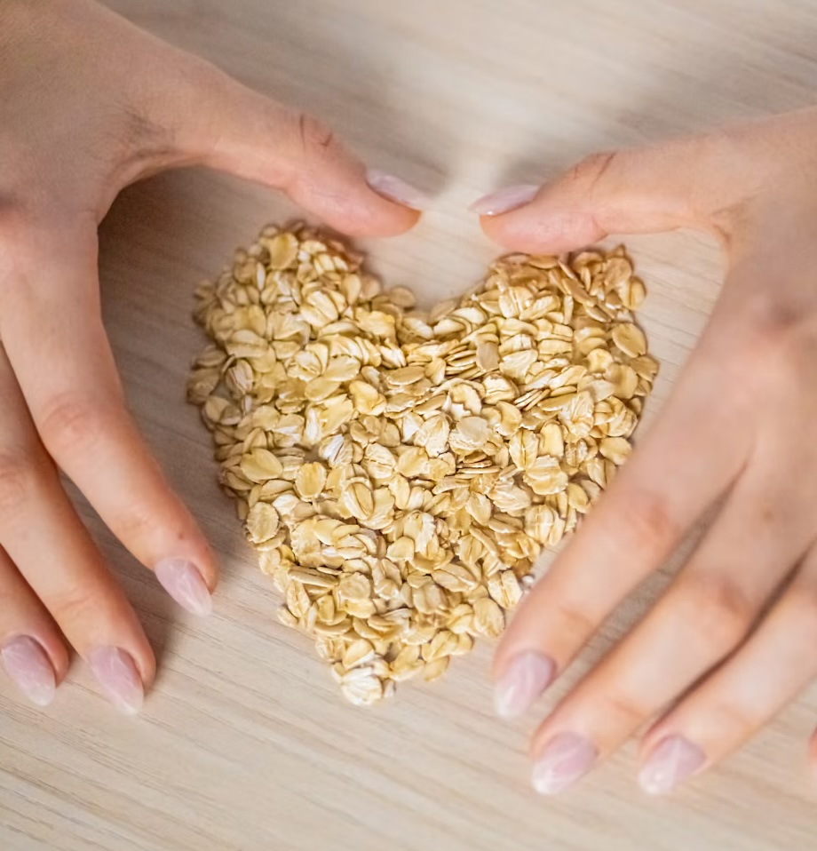 Heart-healthy foods including oats, vegetables, beans, nuts, and fish on a kitchen table.