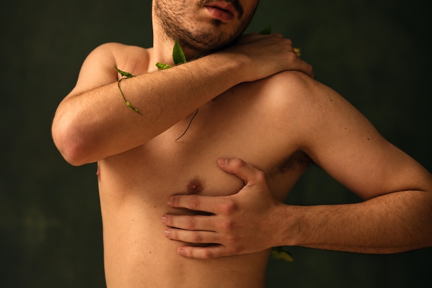 A man standing with his hand over his chest, symbolizing awareness of breast cancer in men. A man standing with his hand over his chest, symbolizing awareness of breast cancer in men.