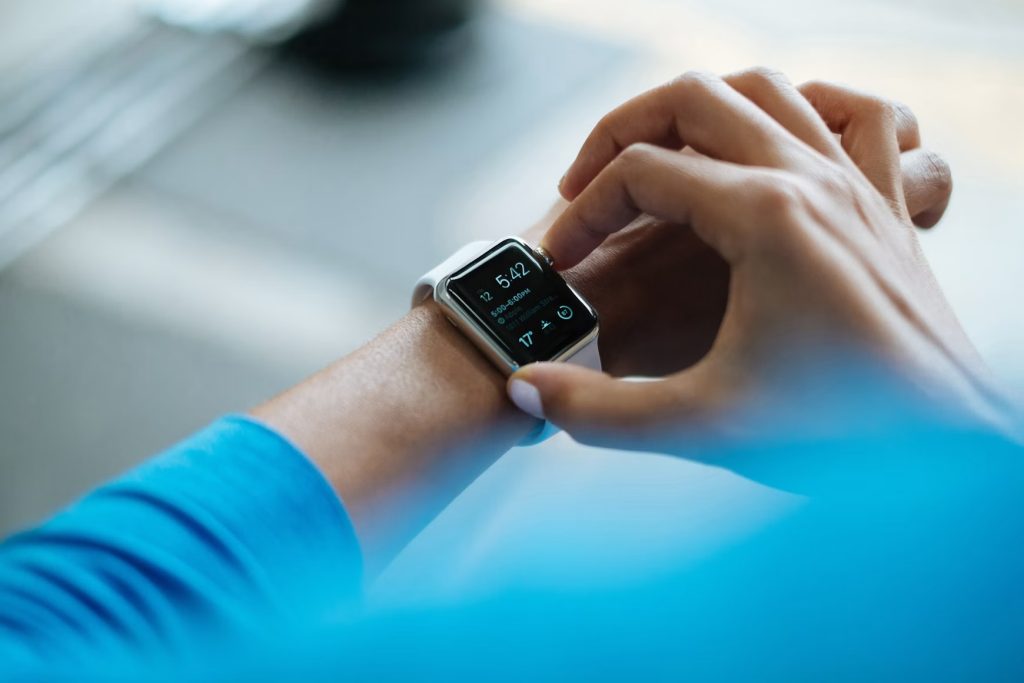 Person checking a smartwatch, illustrating how health tracking devices monitor activity, sleep and other wellness metrics.